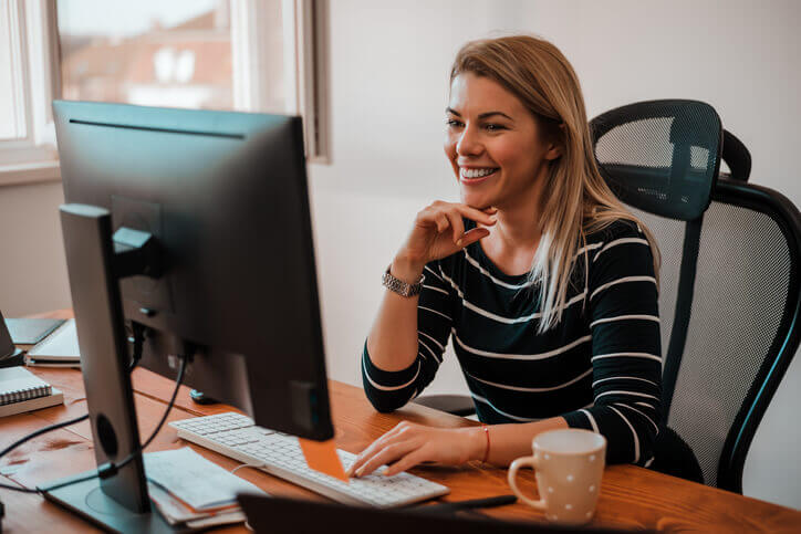 Accomplished female Office Administrator working on a computer after completing an office administration course online in BC