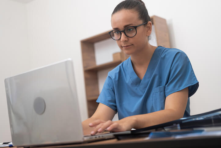 A healthcare professional checking patient files at a front desk